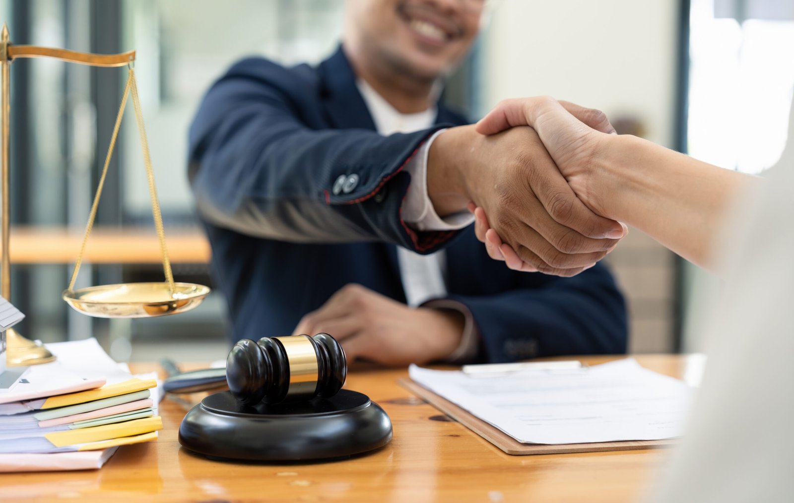 lawyer or attorneys shaking hand with client after consultation discussing a contract agreement customer at courtroom, judge service concept.